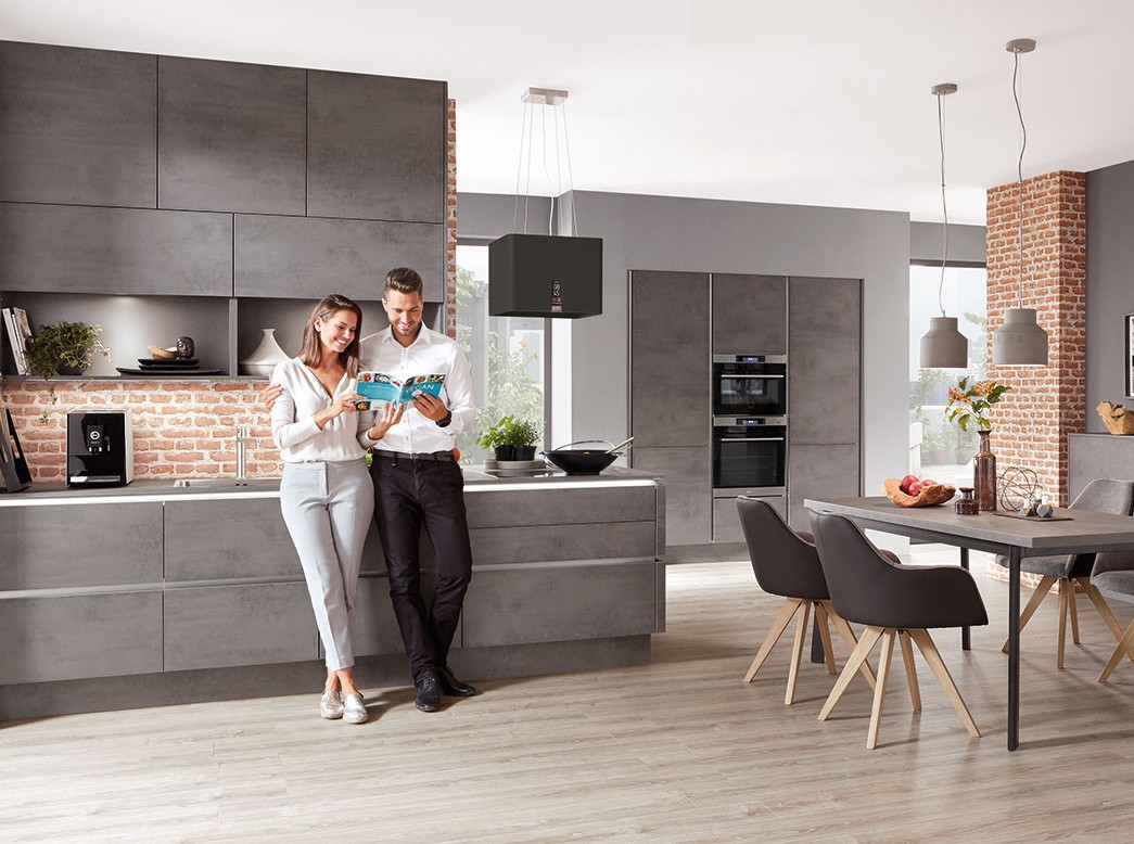 Moderne Wohnküche in Grau mit Kochinsel, Essbereich und offenem Design – stilvoll und gemütlich zugleich.